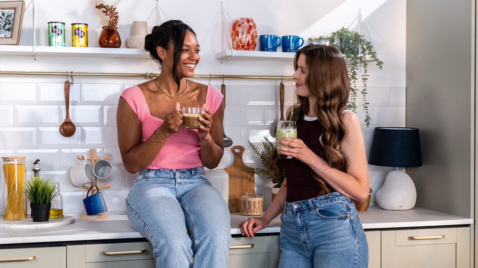 two ladies enjoying matcha chai and vanilla chai in kitchen