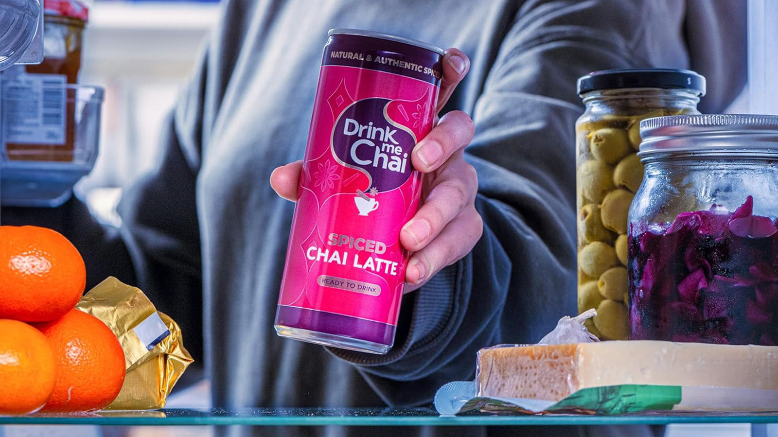 Lady reaching for Drink me Chai ready to drink can in fridge